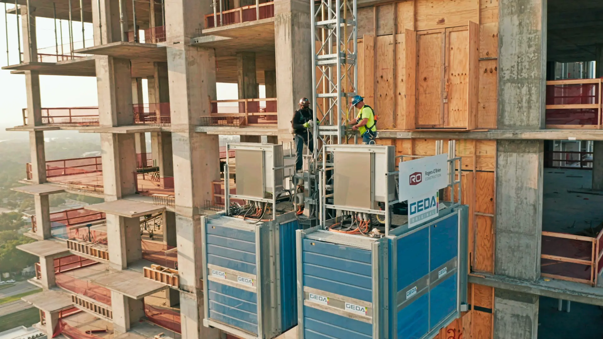 Construction workers on a hoist platform high on an Austin high-rise build