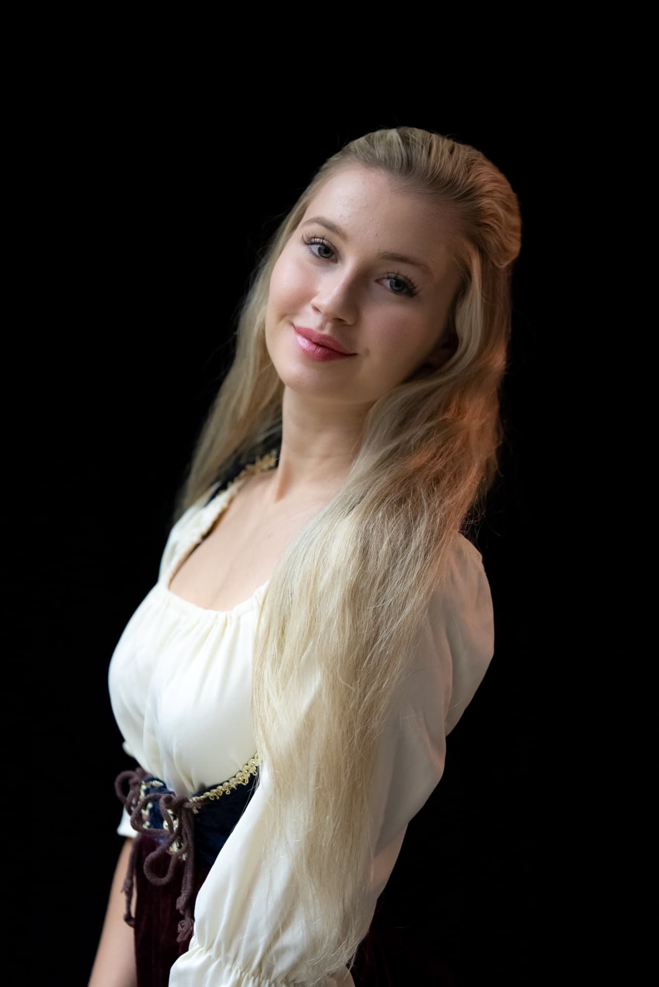Portrait of a woman in traditional dress against a black background